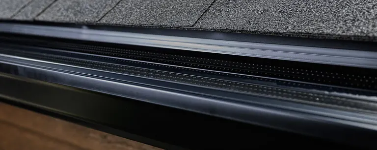 Close-up of the Alu-Rex DoublePro microfiltration continuous hanger on a shingle roof